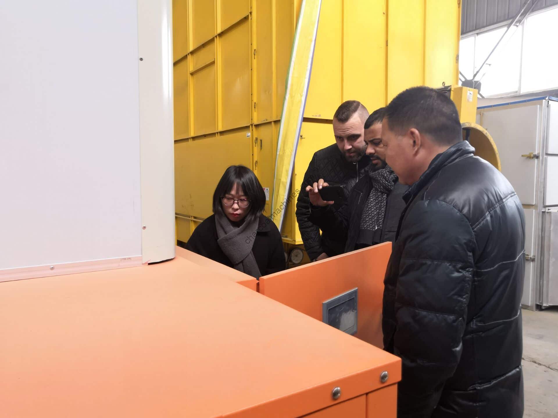 German clients examine the charcoal machine carefully